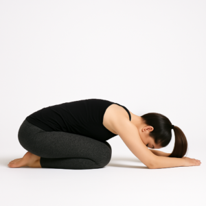 A woman doing a gentle yoga pose called the Child's Pose.